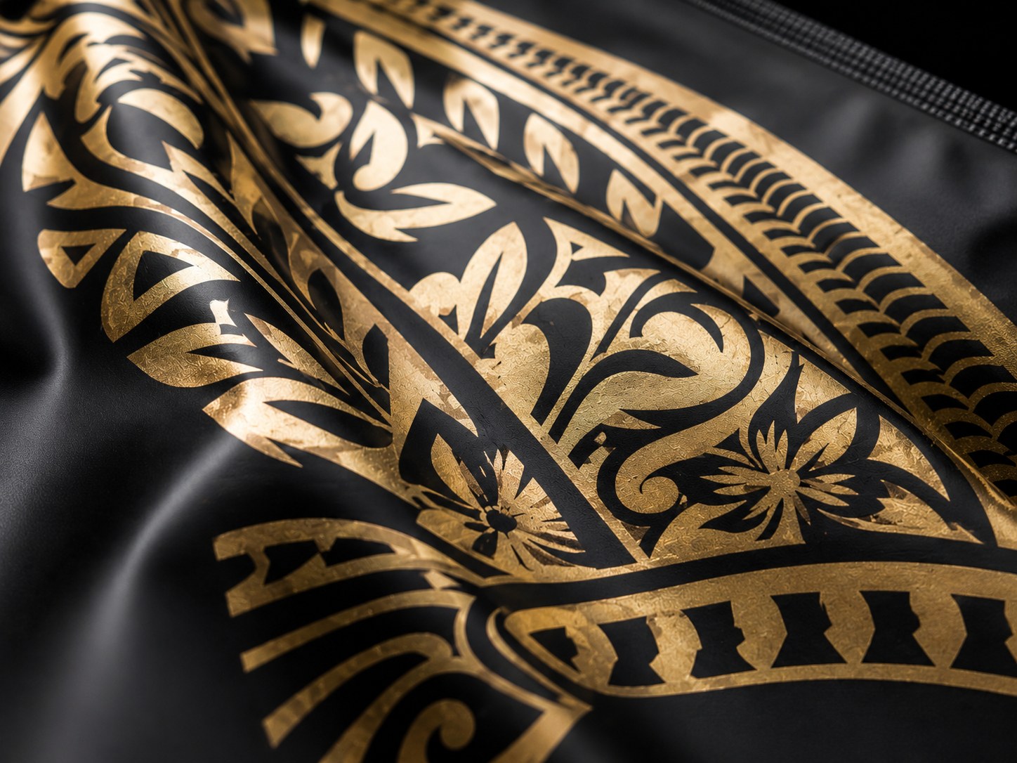 Detail of the hand drawn KONA tribal print in gold on black packaging